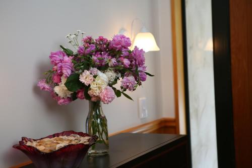 a vase filled with purple and white flowers on a table at Star Dream Manor in Lake Tekapo
