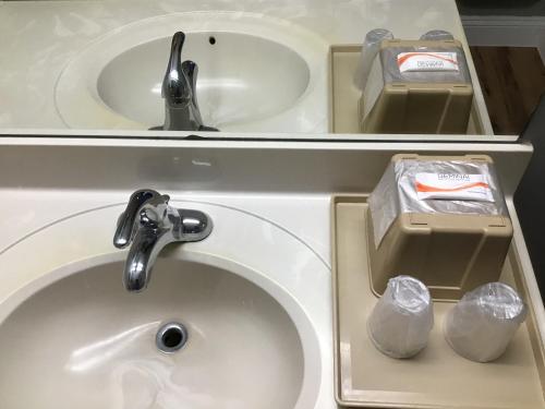 a bathroom with two sinks and a faucet at Scottish Inns in Richmond Hill