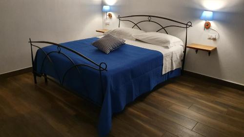 um quarto com uma cama com um cobertor azul e 2 candeeiros em DOMU NOSTA di Giulio & Ignazia Room1 em Santa Luria