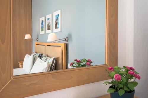a mirror reflecting a bed in a hotel room at Anna Plakias Apartments in Plakias
