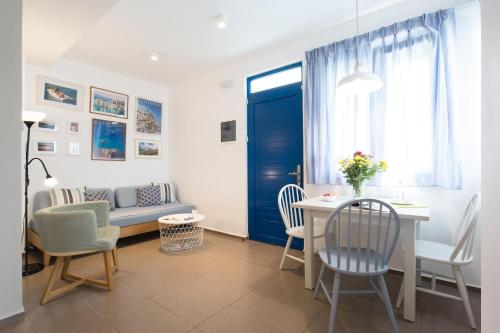 a living room with a couch and a table and chairs at Anna Plakias Apartments in Plakias