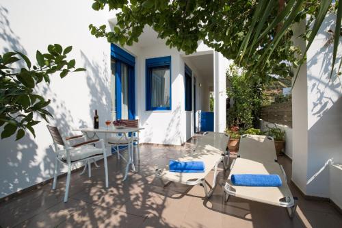 a patio with white chairs and a table and chairs at Anna Plakias Apartments in Plakias