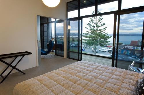 a bedroom with a bed and a view of the ocean at Vue Apartments in Napier