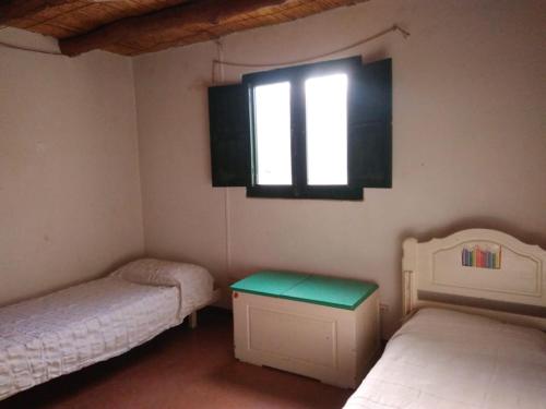 a small room with two beds and a window at Cabaña en Olivar Centenario Agroecológico Tutuna in Pocito