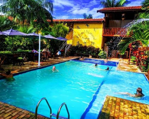a group of people swimming in a swimming pool at Hotel Natural - SPA & Lazer in Brotas