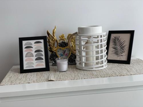 a shelf with pictures and a vase on it at Apartament45 in Giżycko