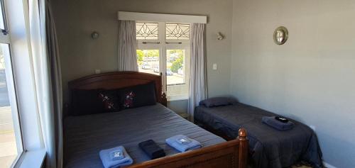 a bedroom with two beds and a window at Hotel Motueka Backpackers, Loud Live Music Friday Saturday Nights in Motueka