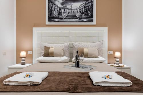 una camera da letto con un grande letto con due asciugamani di Residenze Chamur Via Volturno a Palermo