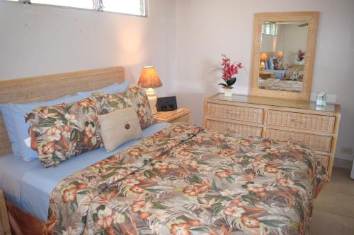 1 dormitorio con 1 cama y vestidor con espejo en Kalama Terrace P309 en Kihei