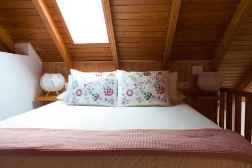 Bett mit weißer Bettwäsche und Kissen in einem Zimmer in der Unterkunft Lujoso y moderno dúplex con fantástica terraza in La Laguna