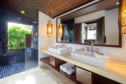uma casa de banho com 2 lavatórios e um chuveiro em The Vijitt Resort Phuket - SHA Extra Plus em Praia de Rawai