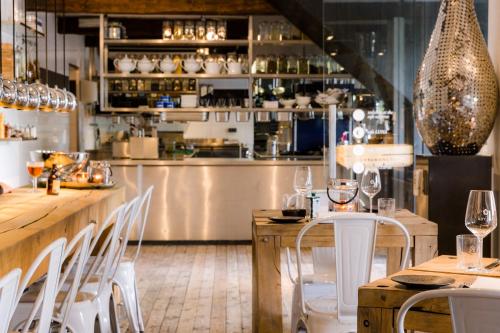 un restaurante con un bar con mesas y sillas blancas en Houseboat Martinique, en Maastricht