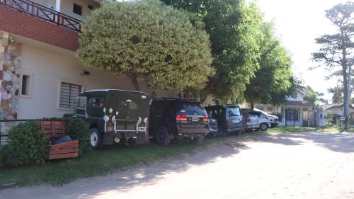 un par de vehículos estacionados al lado de una casa en Hotel Albert en Villa Gesell