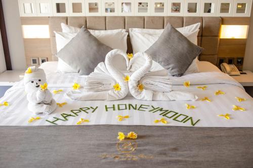 a bed with two stuffed animals and flowers on it at Jimbaran Bay Beach Resort and Spa by Prabhu in Jimbaran