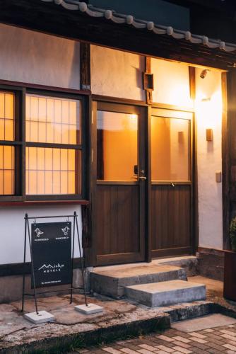 a house with a sign in front of a door at MINKA Riverside Villas in Imizu