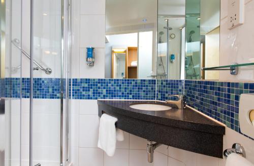 uma casa de banho com um lavatório e um chuveiro em Holiday Inn Express Newcastle City Centre, an IHG Hotel em Newcastle upon Tyne