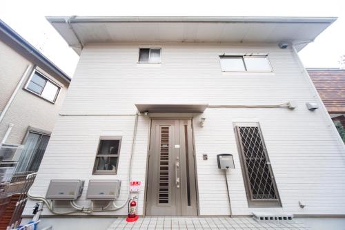 a white building with a door on the side of it at Awaji Central Inn Kuruma713 in Awaji