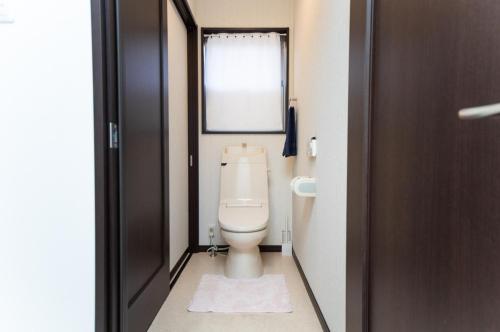 a bathroom with a toilet and a window at Awaji Central Inn Kuruma713 in Awaji