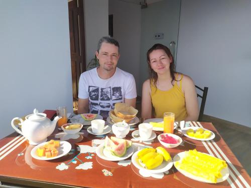 un homme et une femme assis à une table avec de la nourriture dans l'établissement Mahaweli King's Villa, à Kandy
