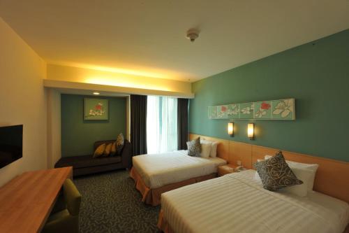 a hotel room with two beds and a television at The Everly Putrajaya in Putrajaya