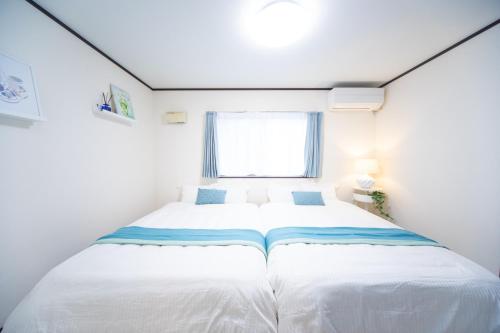 a bedroom with a large white bed in a room at Awaji Central Inn Kuruma713 in Awaji