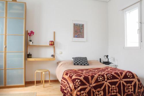 a bedroom with a bed and a stool in it at Hipster Studio in Anton Martin by Allô Housing in Madrid