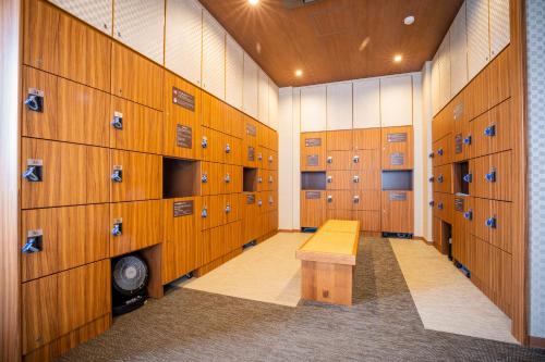 a locker room with wooden lockers and a yellow bench at La Vista Furano Hills Natural Hot Spring in Furano