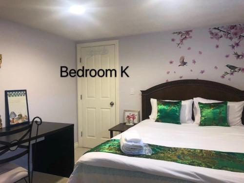 a bedroom with a bed with a bedroomk sign on the wall at Hamptons Rose garden family! in Calgary