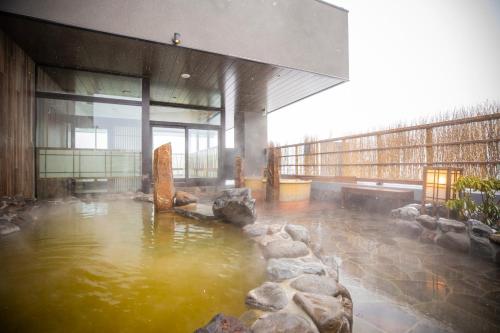 富良野La Vista Furano Hills Natural Hot Spring的大楼内带水池的房间