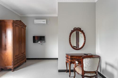a room with a mirror and a chair and a desk at RedDoorz Syariah near Exit Toll Banyumanik Semarang in Srondolwetan