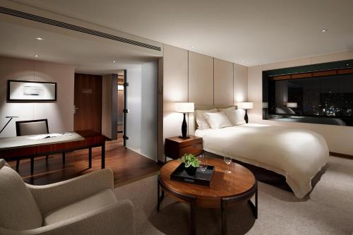 ソウルにあるソウル新羅ホテルのベッドとデスクが備わる広い客室です。