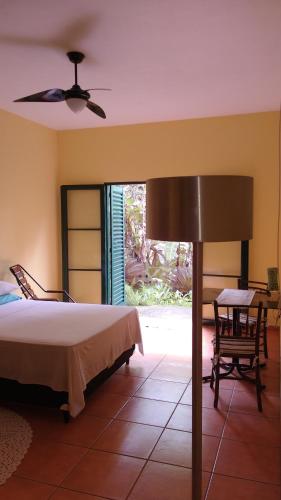 a bedroom with a bed and a table and a lamp at Suítes Brotas City in Brotas