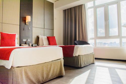 a hotel room with two beds and a window at Onomo Hotel Dar es Salaam in Dar es Salaam