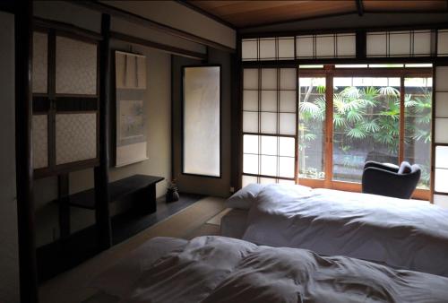 Un dormitorio con una cama grande y una ventana en IZUYASU Traditional Kyoto Inn serving Kyoto cuisine en Kyoto