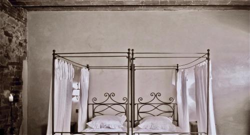 a black and white photo of a bed with two pillows at La Saracina in Pienza