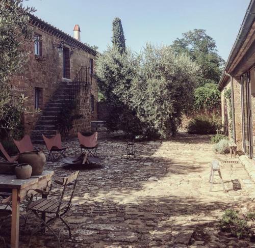 a courtyard with chairs and stairs in a building at La Saracina in Pienza