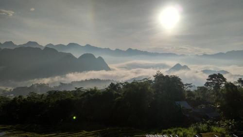 a misty mountain valley with the sun in the sky at PU LUONG BOUTIQUE GARDEN in Pu Luong