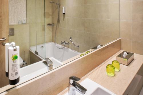 a bathroom with a tub and a sink and a shower at Holiday Inn Frankfurt Airport by IHG in Frankfurt/Main