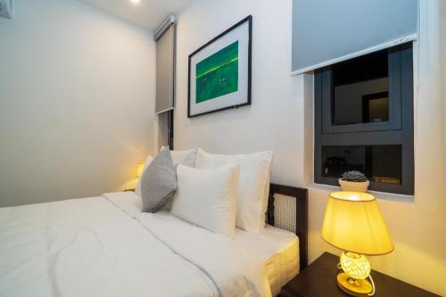 a bedroom with a white bed with a window and a lamp at Hoi An Gravel Pool Villa & Spa in Hoi An