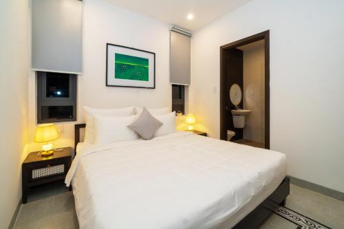 a bedroom with a large white bed and a window at Hoi An Gravel Pool Villa & Spa in Hoi An