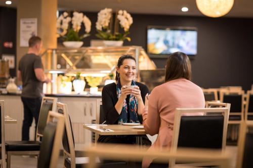 two women sitting at a table with a microphone at Mawson Lakes Hotel in Adelaide