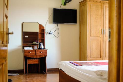 a bedroom with a bed and a dresser and a mirror at Sapa Sunrise Hotel in Sapa