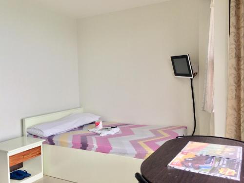 a small bedroom with a bed and a table at LCF - BB Hotel in Romblon