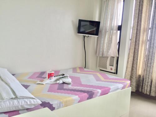 a small bedroom with a bed with a tv on it at LCF - BB Hotel in Romblon