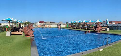 a pool at a resort with people playing in it at Sulis Beach Hotel & Spa in Kuta