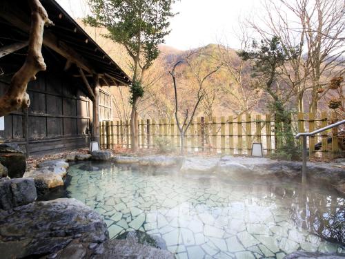a pool of water in a yard with a fence at Ginshotei Awashima in Numata