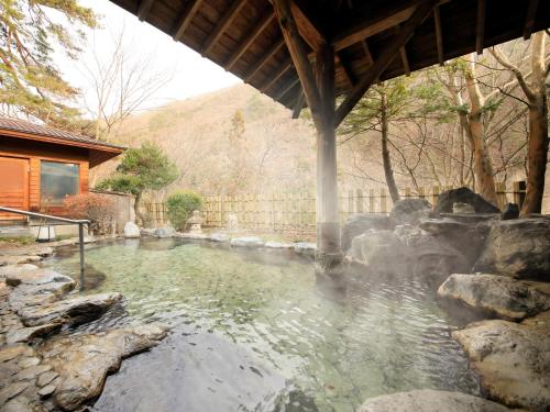 a pool of water in a yard with a building at Ginshotei Awashima in Numata