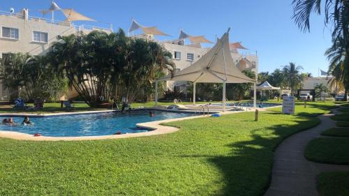 a swimming pool in a park with people in it at Renta de departamento en Acapulco Diamante in Acapulco