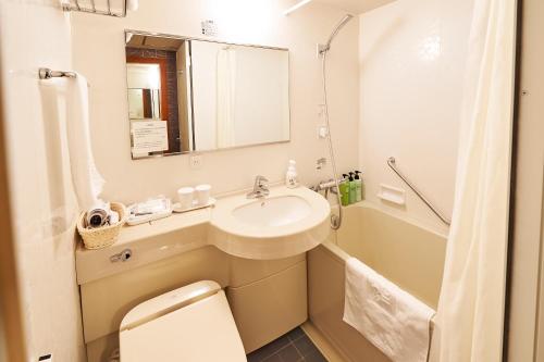 łazienka z umywalką, toaletą i wanną w obiekcie Sotetsu Fresa Inn Higashi Shinjuku w Tokio