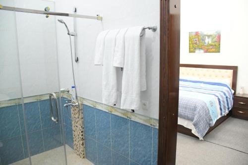 a bathroom with a shower and a bed at Nurziyo Guest House in Tashkent